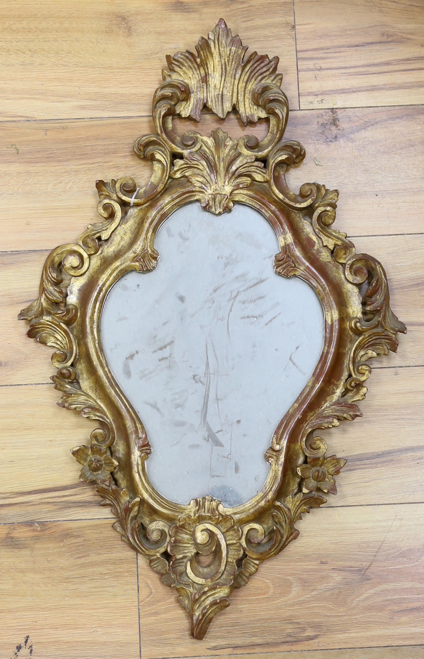 A reproduction gilt framed wall mirror, in the Rococo style, 73cm tall